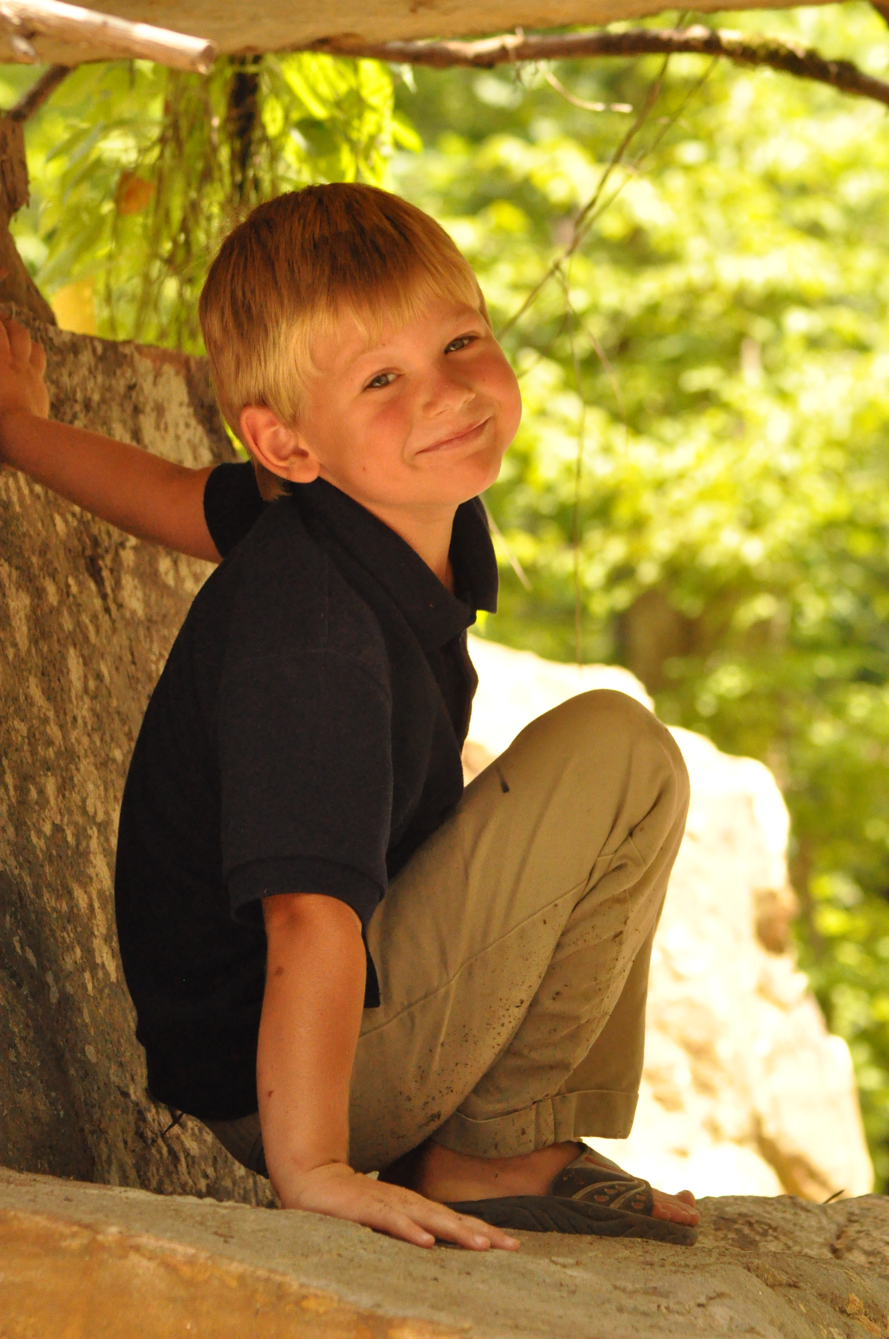 Luke Arthur at a park in 2010 sitting on a rock under a bridge.